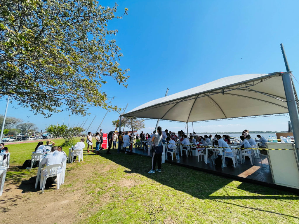 pessoas embaixo de tenda branca fazendo exames de saúde